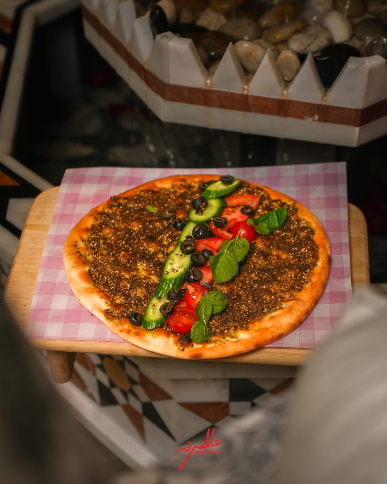 Za'atar manakish topped with fresh mint, cucumber, tomato and olives
